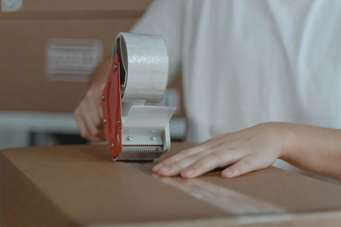 Helfer verpackt Geschirr in Wellpappe